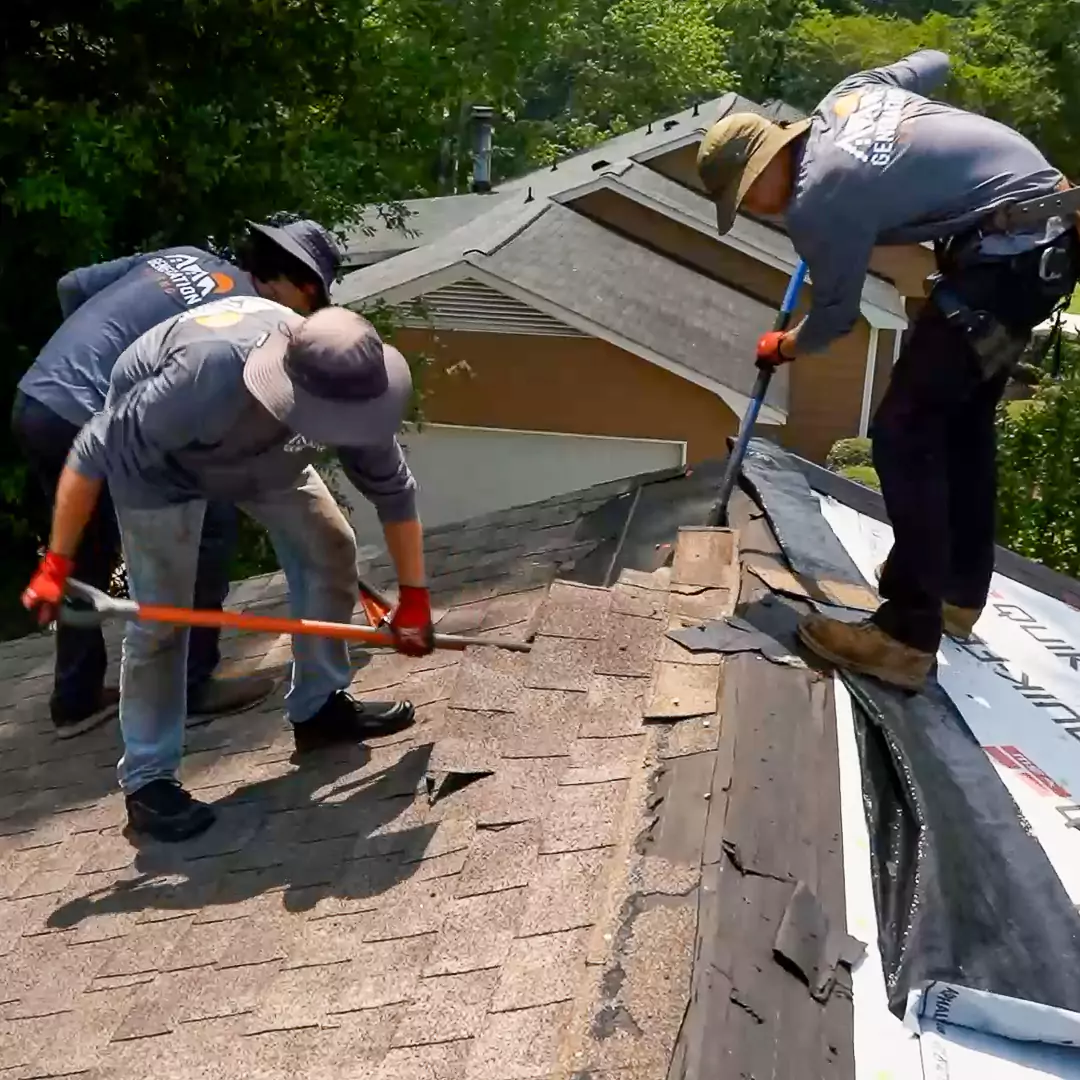 Crew members of Generation Roofing, top-rated roofing service in Upstate South Carolina, tearing off old shingles in preparation for roof replacement.
